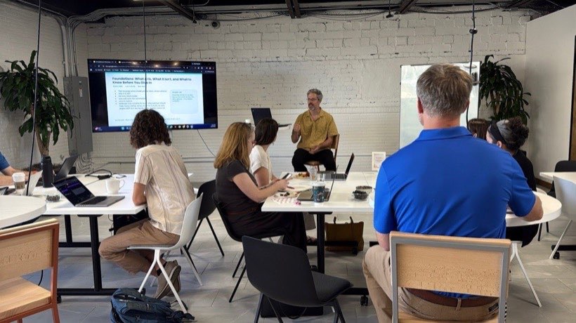Attendees working on laptops at tables during a lab block